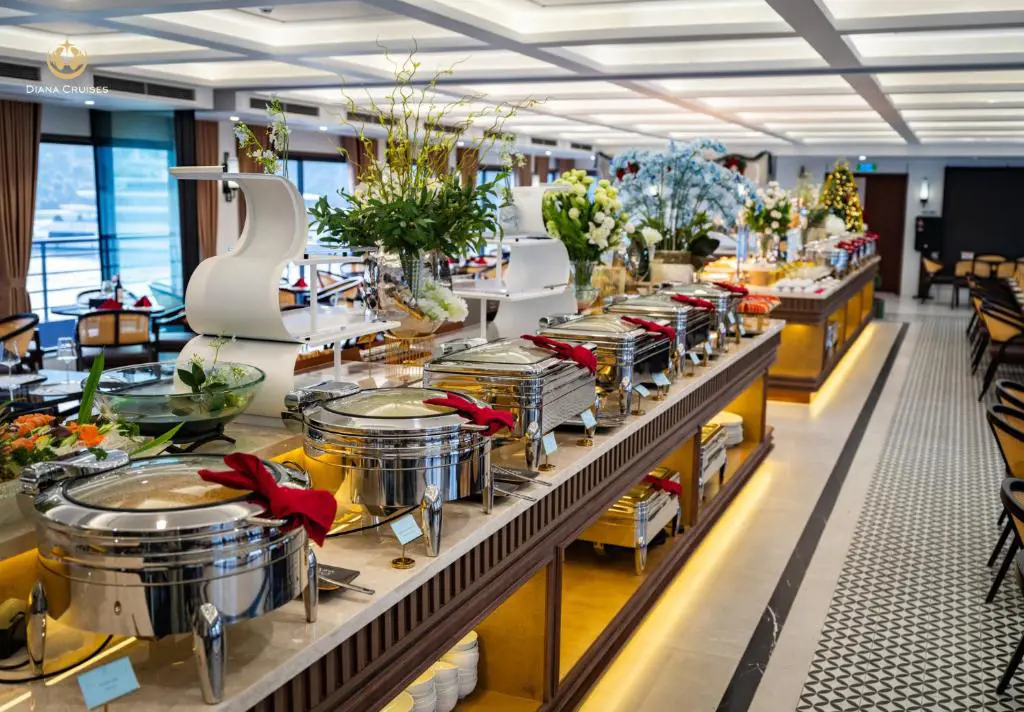 Dãy khay hâm tiệc buffet bằng inox trên quầy gỗ sang trọng tại nhà hàng du thuyền Diana Cruises