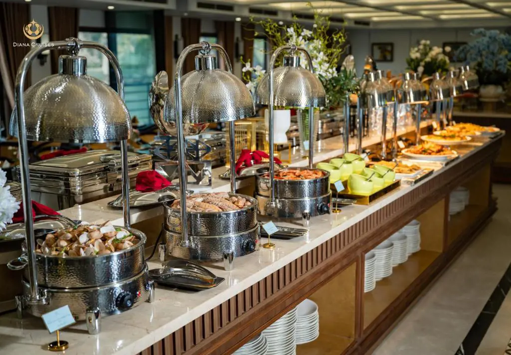 Dãy khay hâm nóng bằng inox chứa món hải sản trên quầy buffet du thuyền