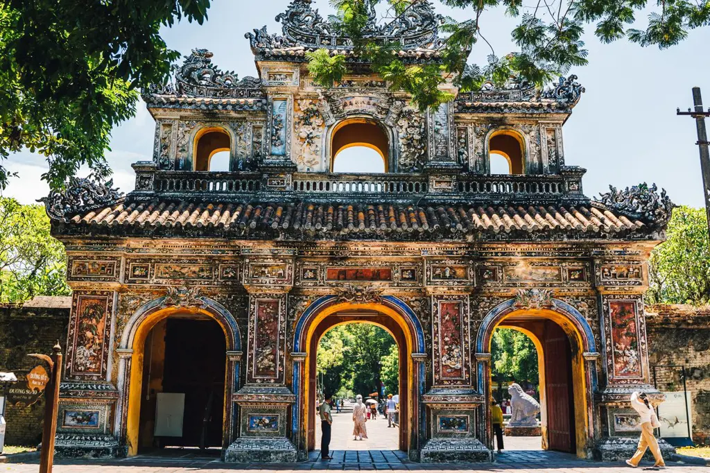 Intricately decorated traditional gateway with three arched entrances and colorful mosaic artwork at the Imperial Citadel in Hue, Vietnam.