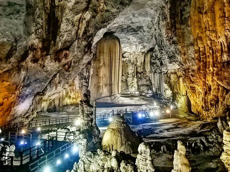 Bên trong hang động Phong Nha - Kẻ Bàng hoành tráng với các cột thạch nhũ khổng lồ và hệ thống lối đi bằng gỗ có đèn chiếu sáng.