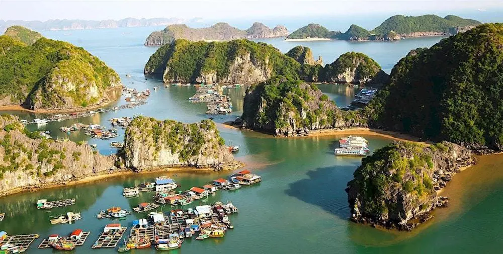 Góc nhìn từ trên cao các nhà nổi, bè nuôi cá và tàu du lịch giữa các đảo đá vôi tại Vịnh Lạn Hạ.